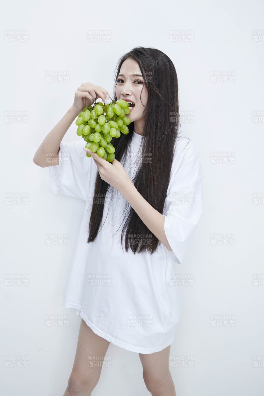 吃葡萄的穿白色長T血衫的長發可愛少女人像