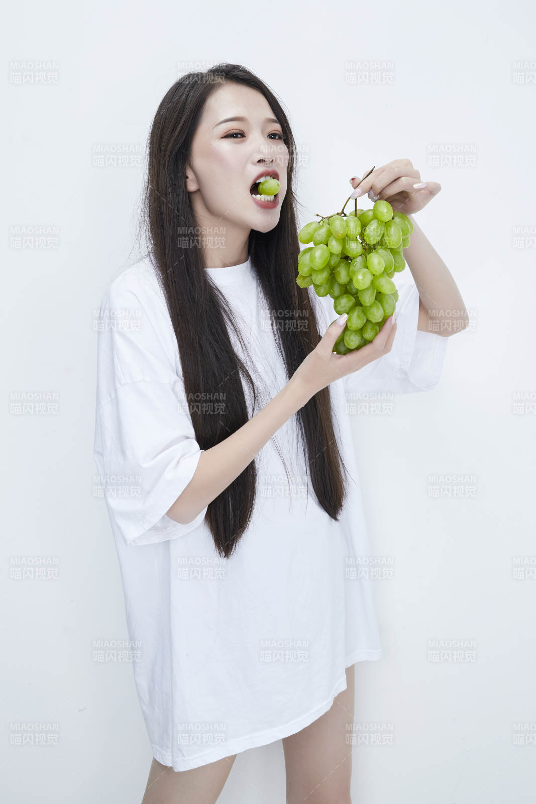 吃葡萄的穿白色長T血衫的長發可愛少女人像