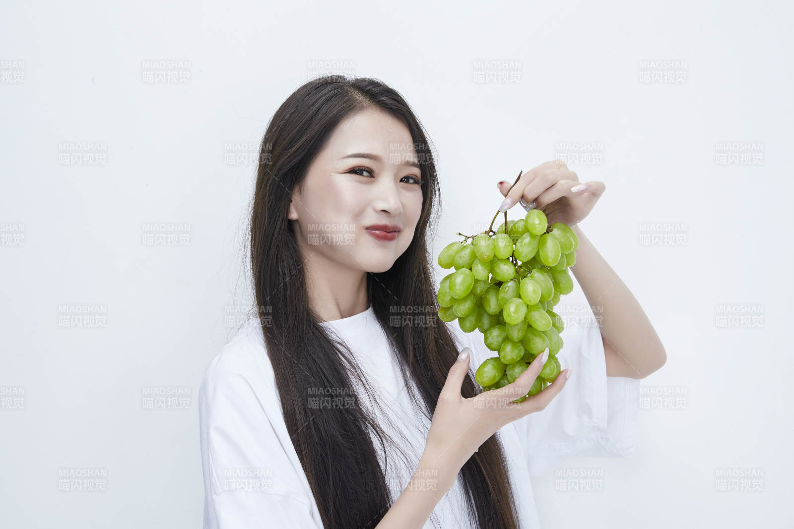 吃葡萄的穿白色長T血衫的長發可愛少女人像