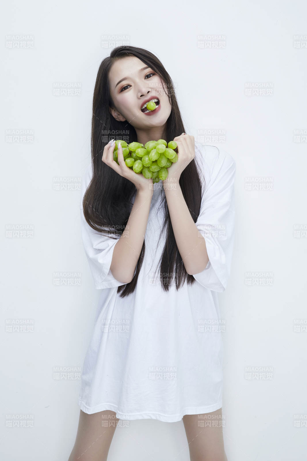 吃葡萄的穿白色長T血衫的長發可愛少女人像