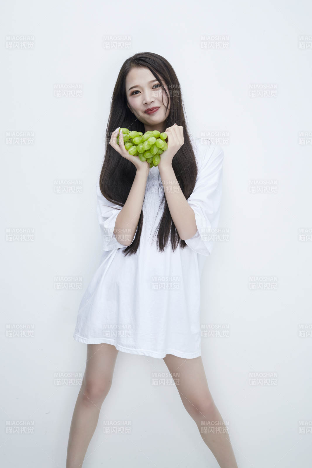 吃葡萄的穿白色長T血衫的長發可愛少女人像