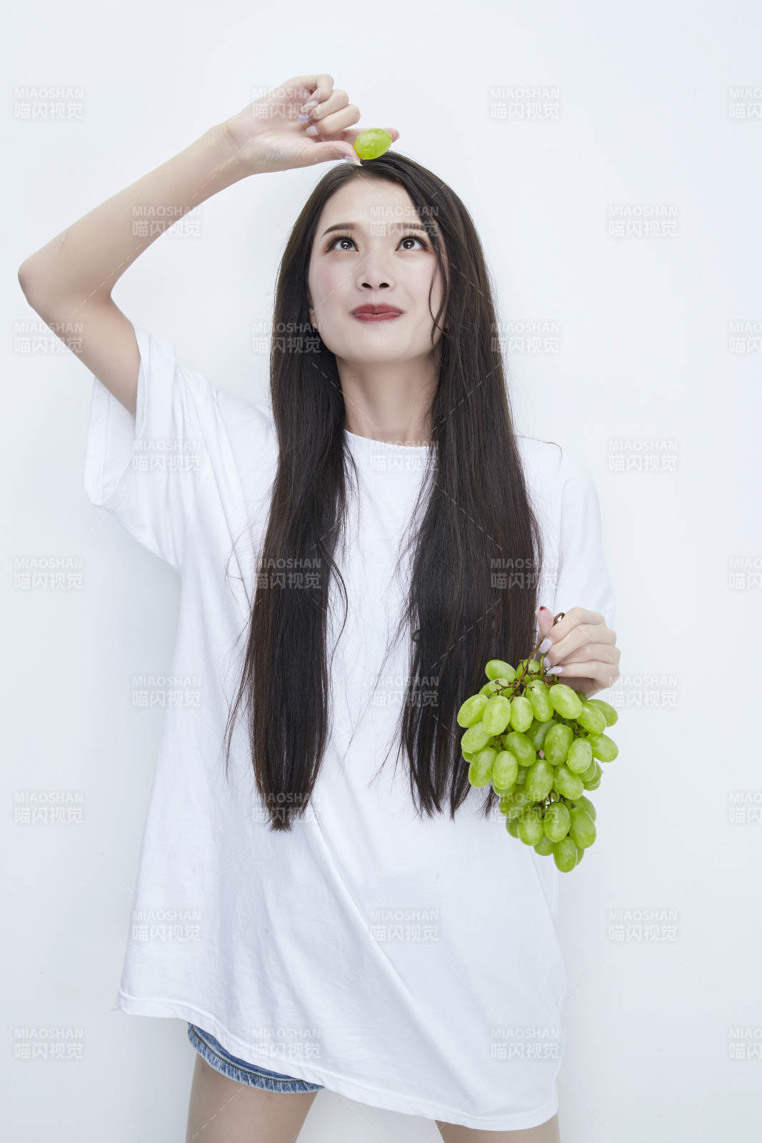 吃葡萄的穿白色長T血衫的長發可愛少女人像