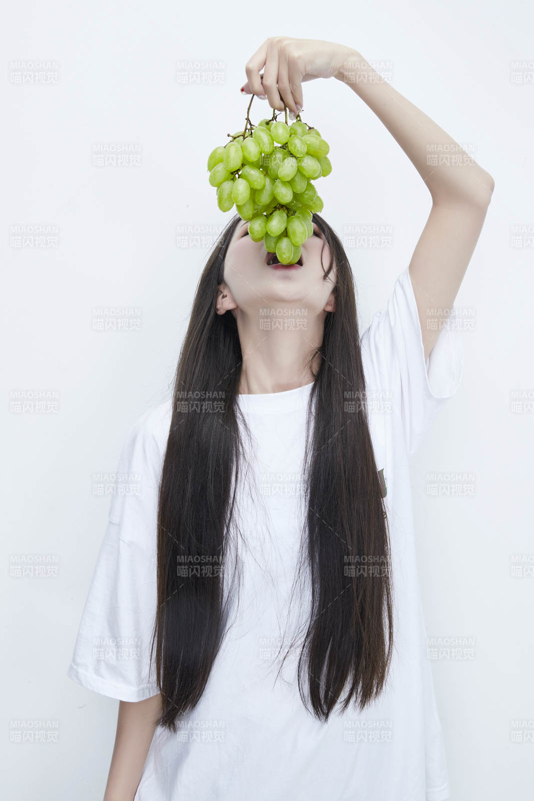 吃葡萄的穿白色長T血衫的長發可愛少女人像