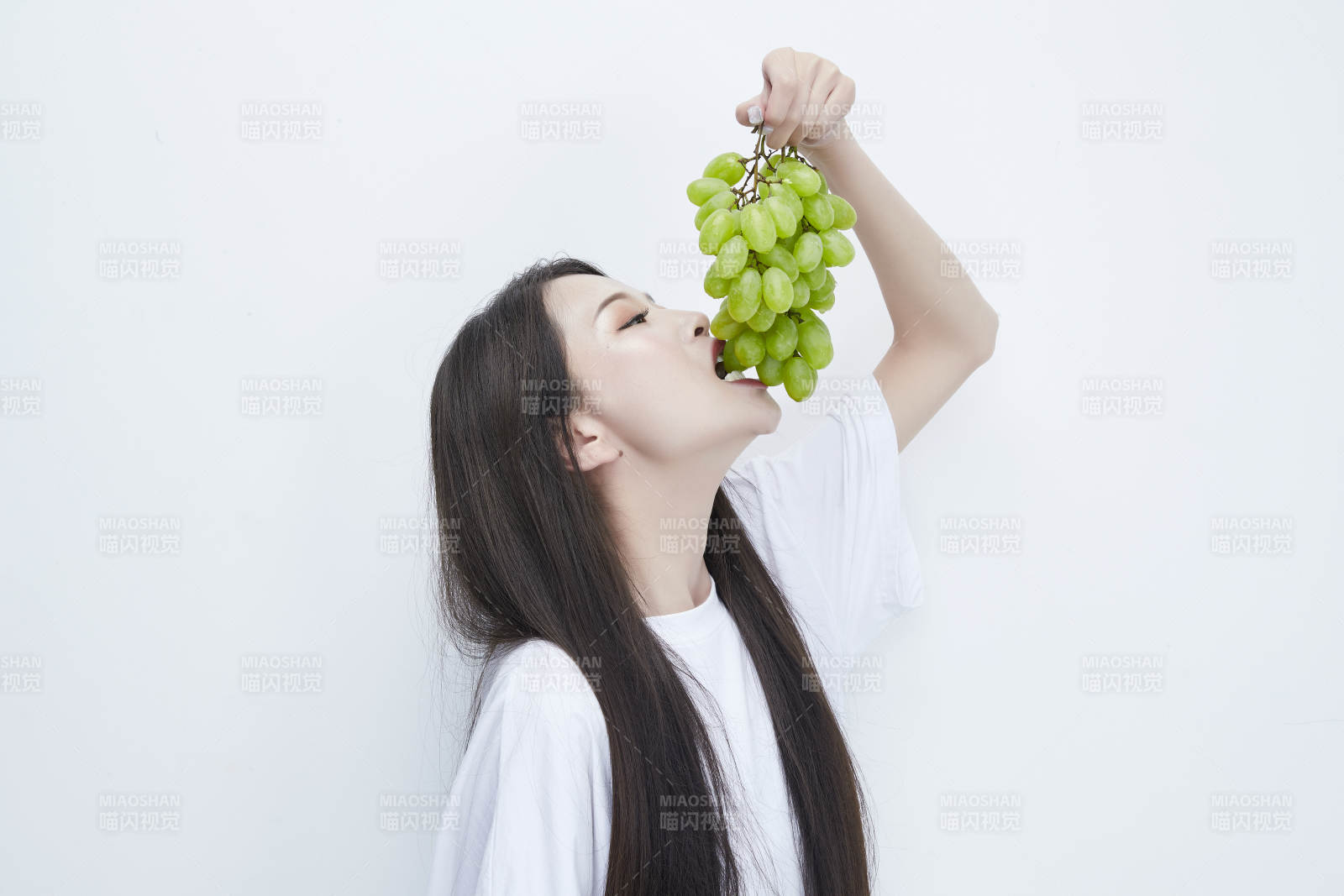 吃葡萄的穿白色長T血衫的長發可愛少女人像