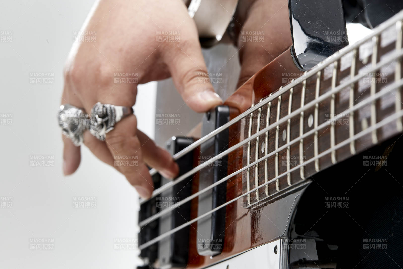 展示貝斯演奏技術技巧的亞洲男性樂手人像局部特寫