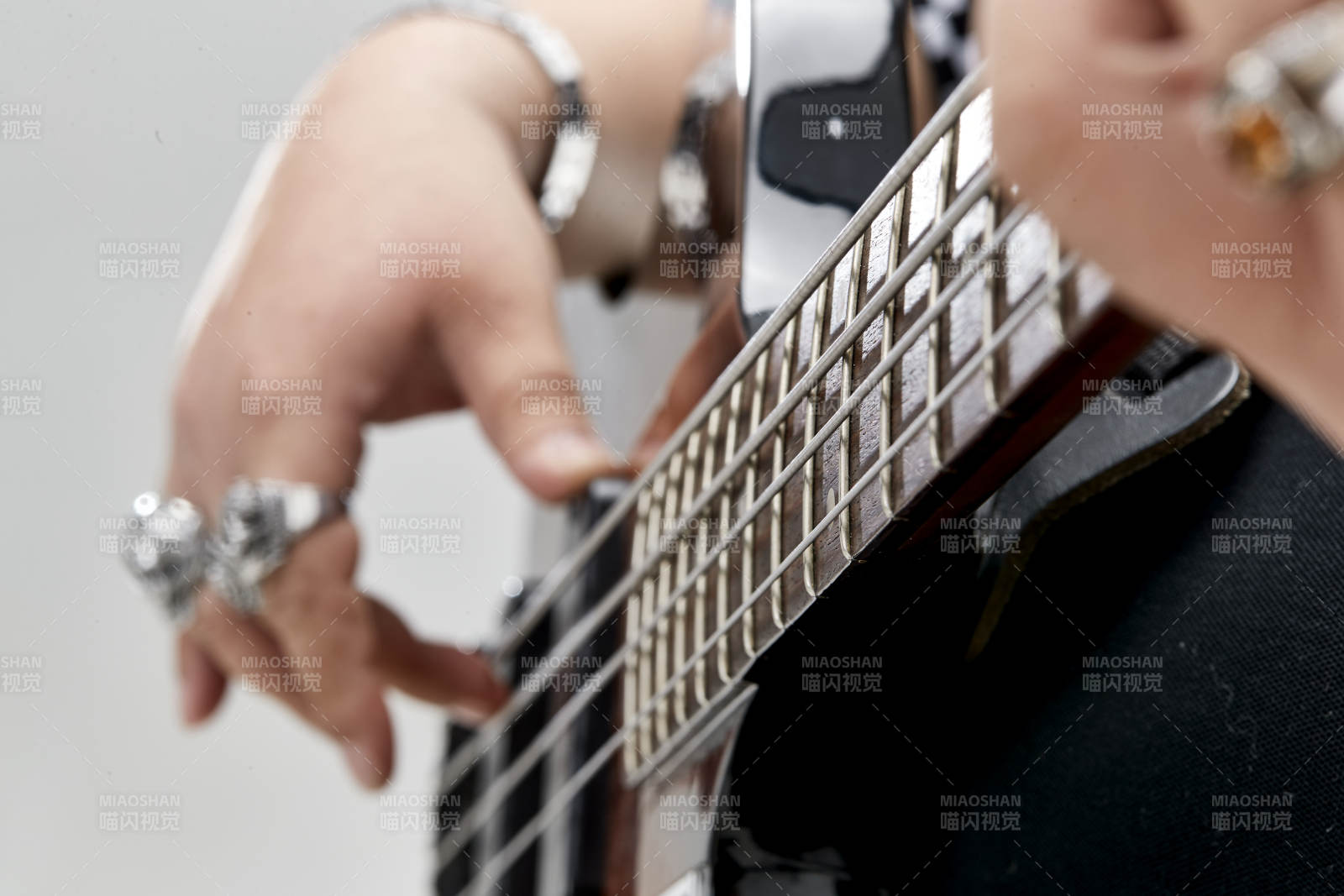 展示貝斯演奏技術技巧的亞洲男性樂手人像局部特寫