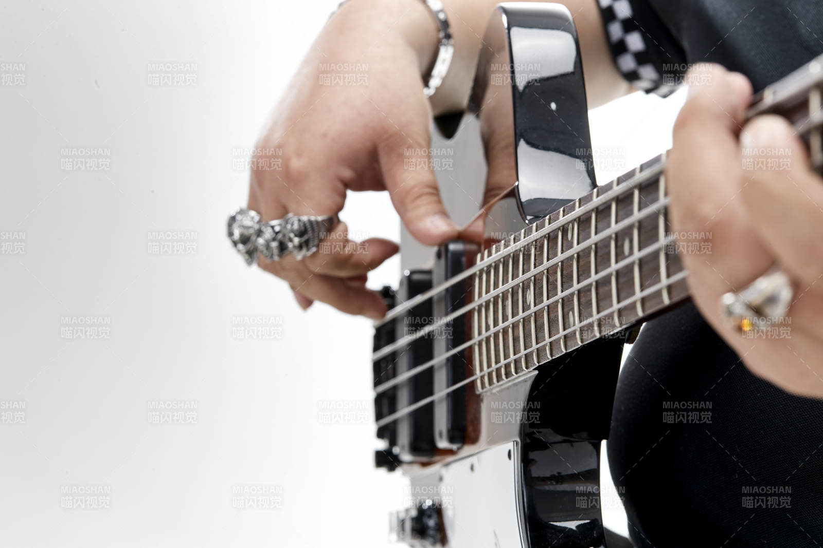 展示貝斯演奏技術技巧的亞洲男性樂手人像局部特寫