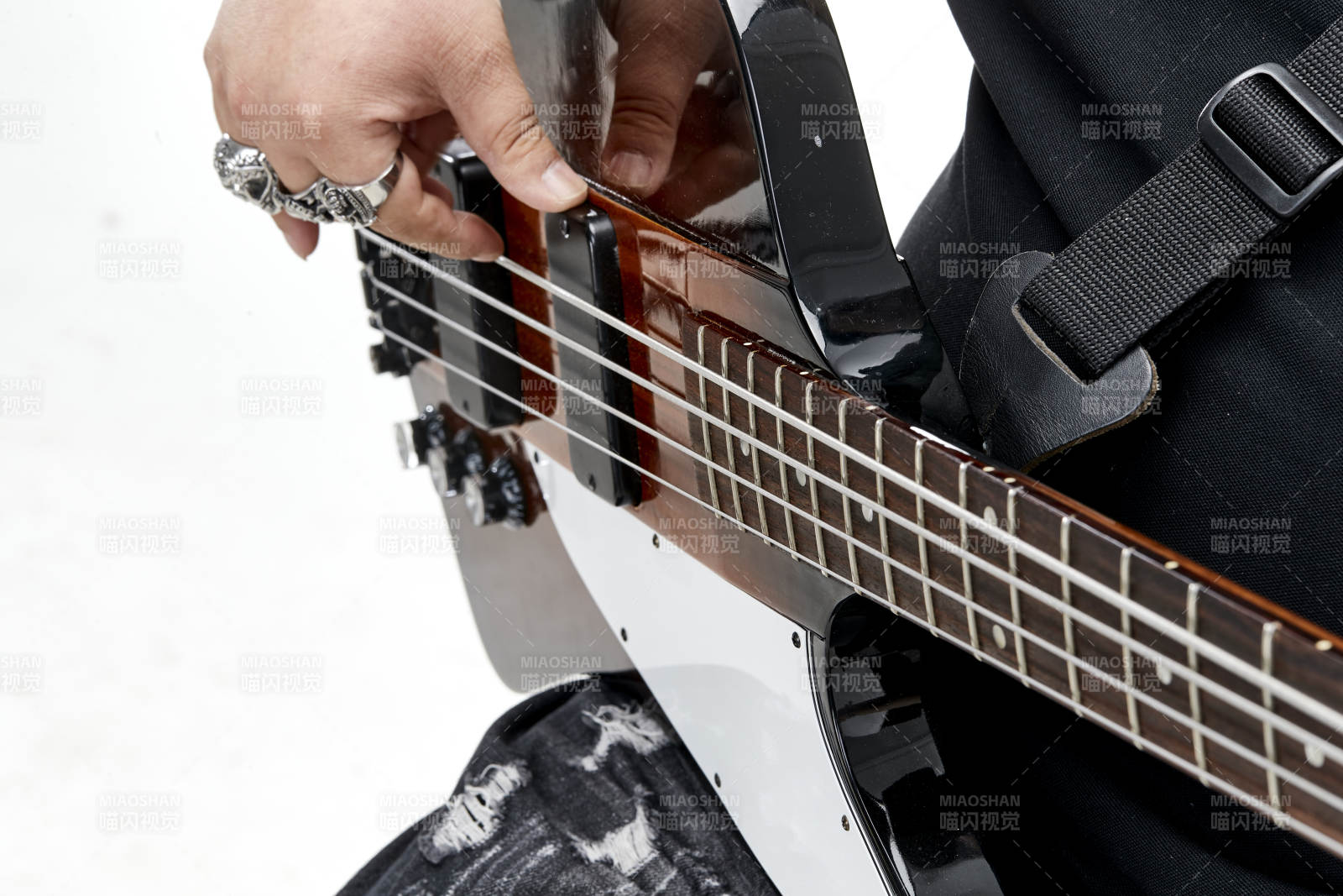 展示貝斯演奏技術技巧的亞洲男性樂手人像局部特寫