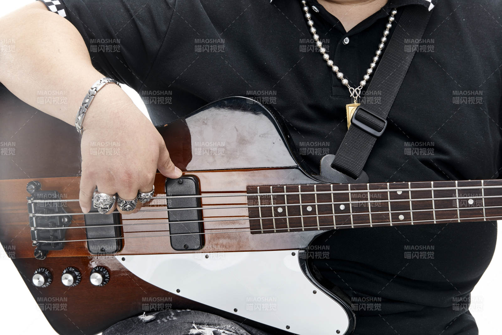 展示贝斯演奏技术技巧的亚洲男性乐手人像局部特写