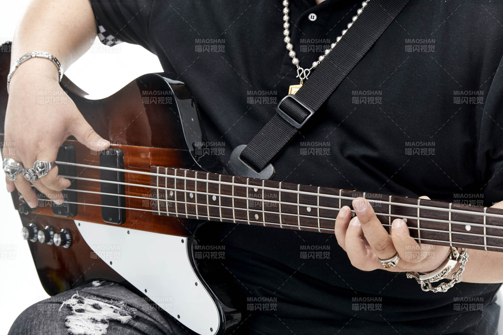 展示贝斯演奏技术技巧的亚洲男性乐手人像局部特写