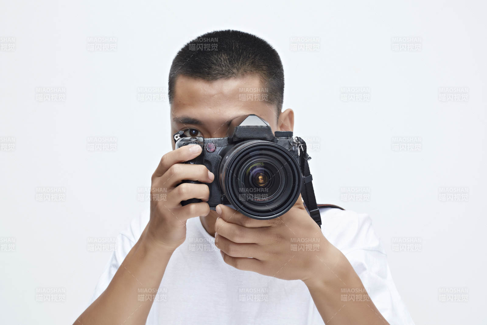白色背景下手持照相機(jī)的亞洲男性攝影師