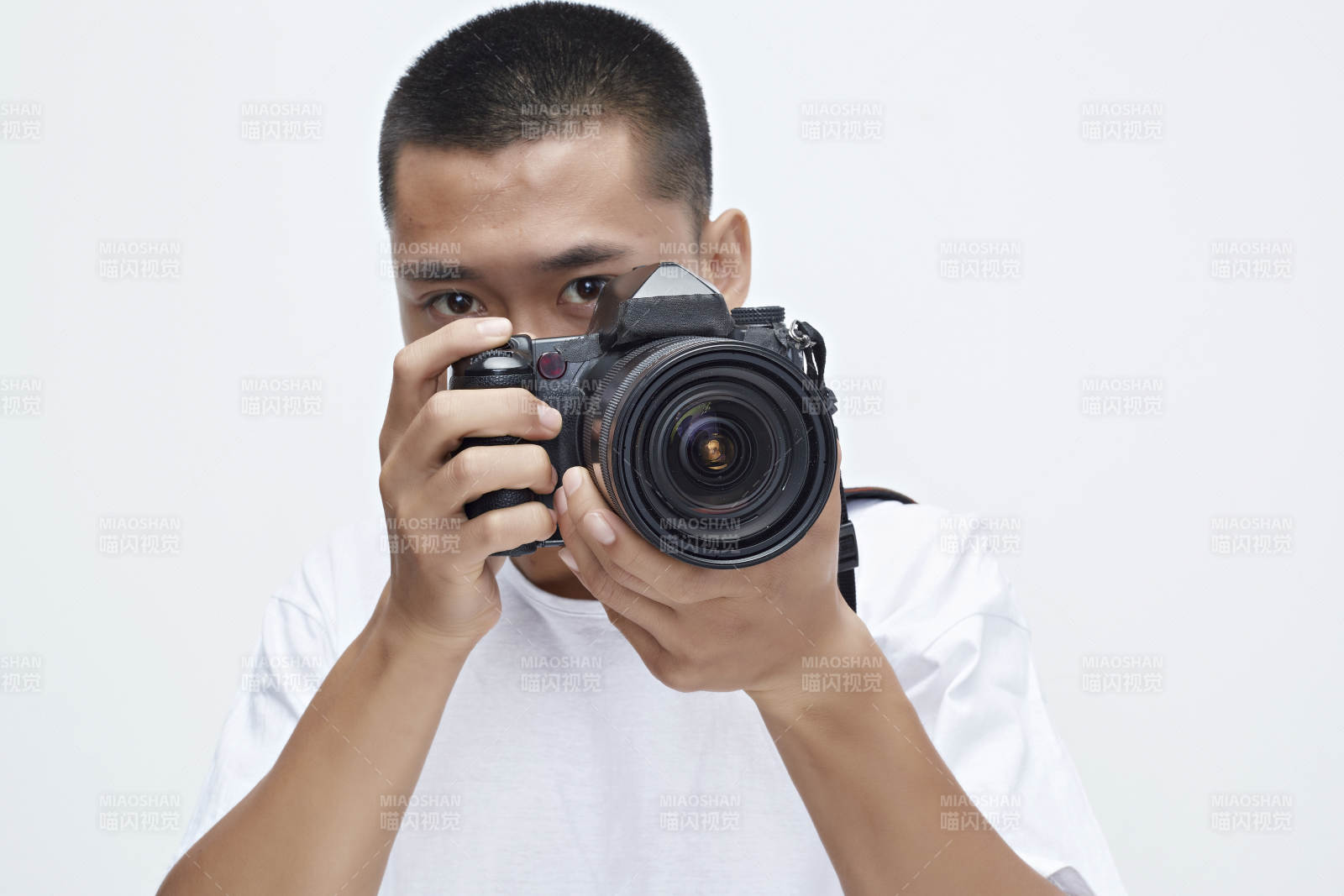 白色背景下手持照相機(jī)的亞洲男性攝影師