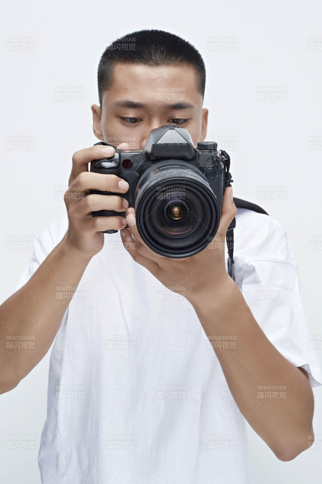白色背景下手持照相機的亞洲男性攝影師