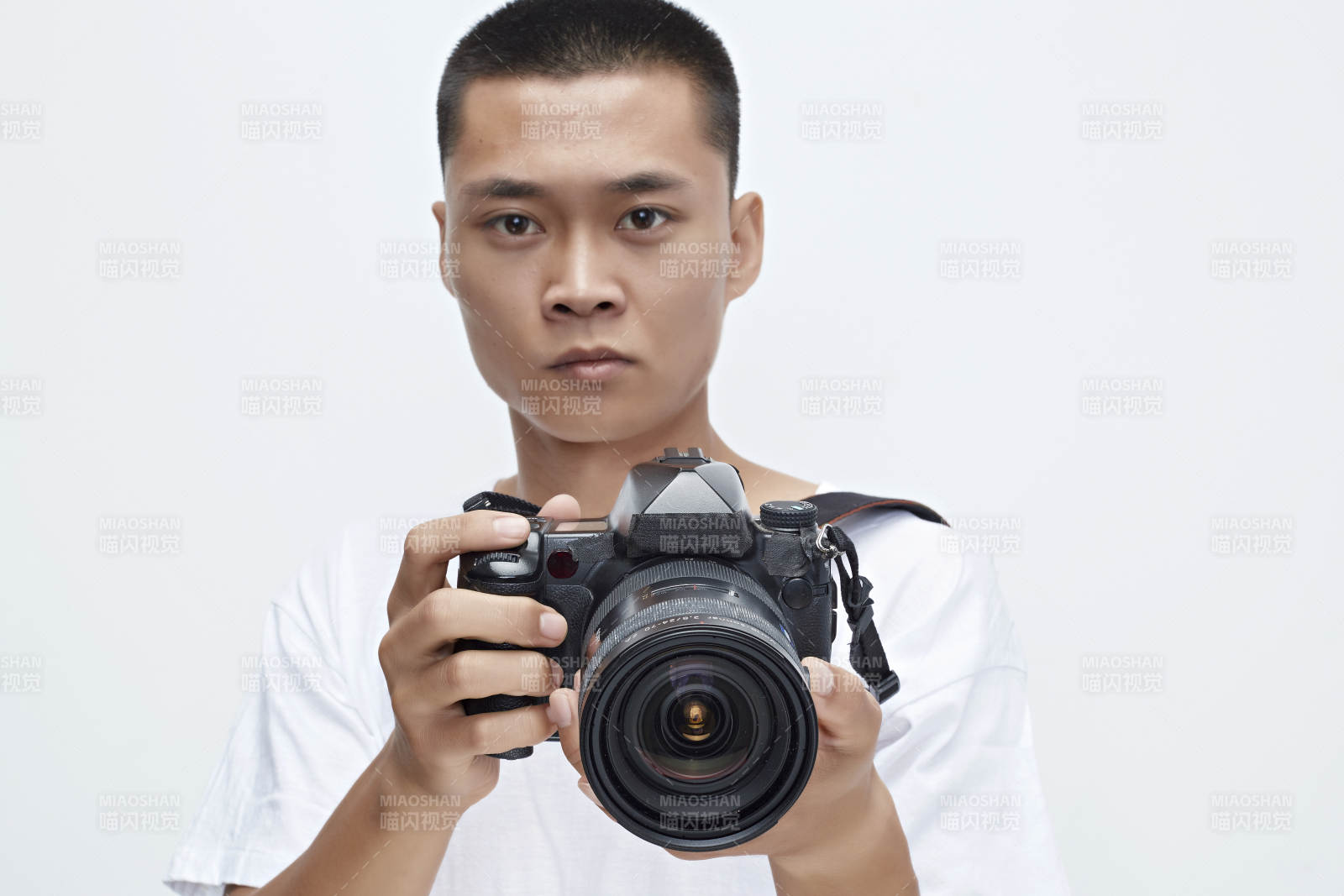 白色背景下手持照相機的亞洲男性攝影師