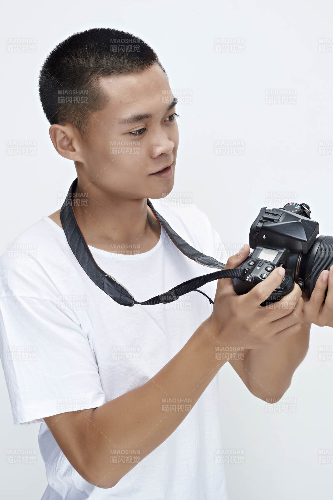 白色背景下手持照相机的亚洲男性摄影师