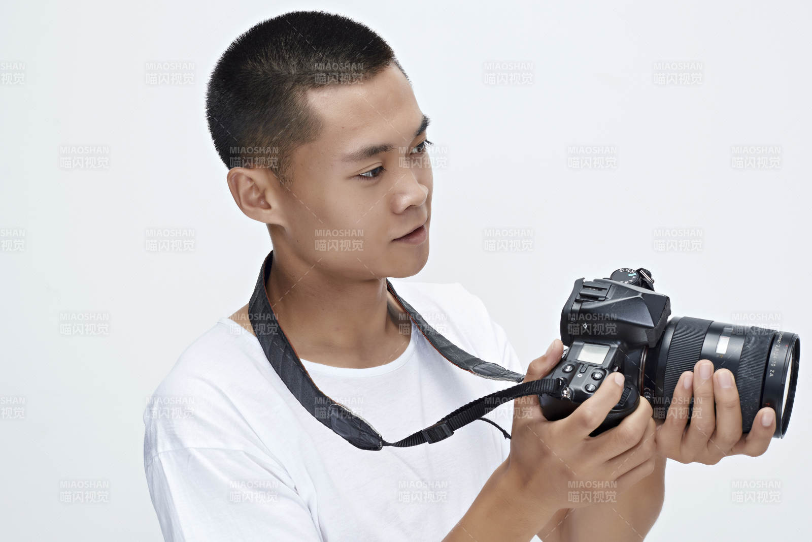 白色背景下手持照相機的亞洲男性攝影師