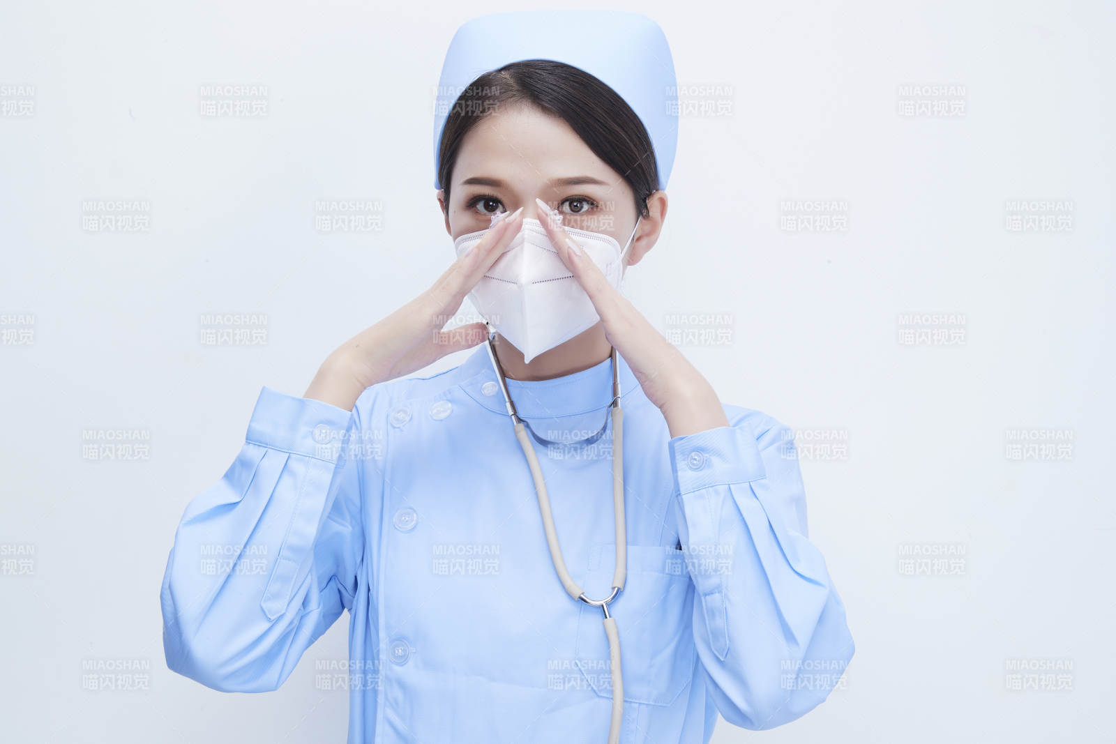 女性醫(yī)護人員展示規(guī)范的口罩正確佩戴方式
