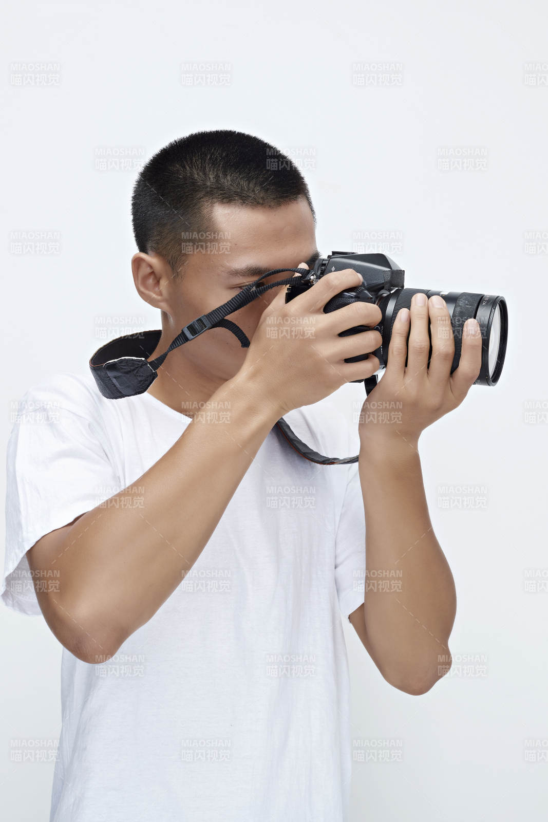 白色背景下手持照相機的亞洲男性攝影師
