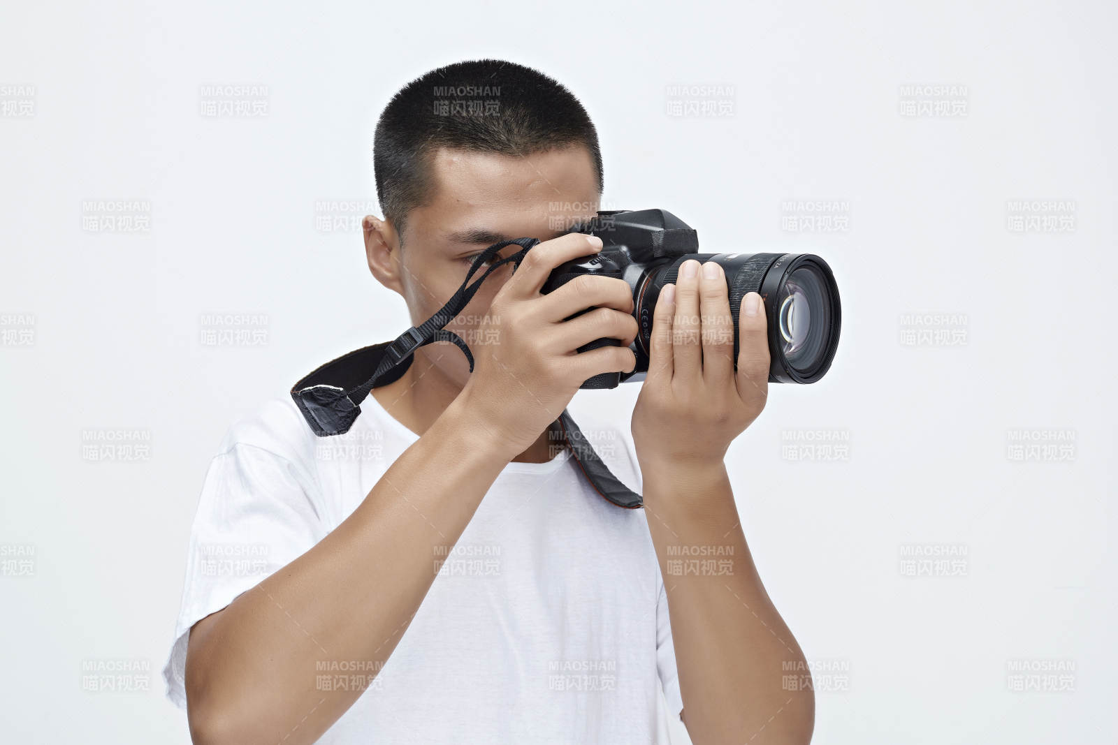 白色背景下手持照相機的亞洲男性攝影師