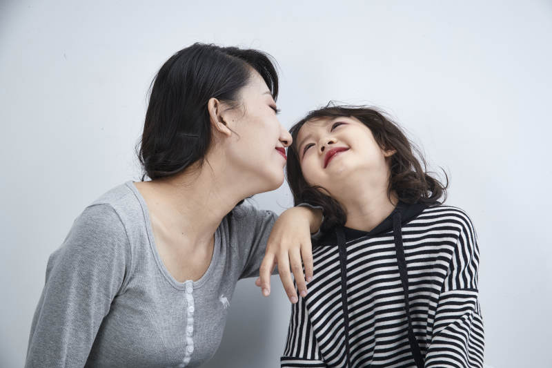 白色背景的美丽妈妈与可爱女儿亲子人像