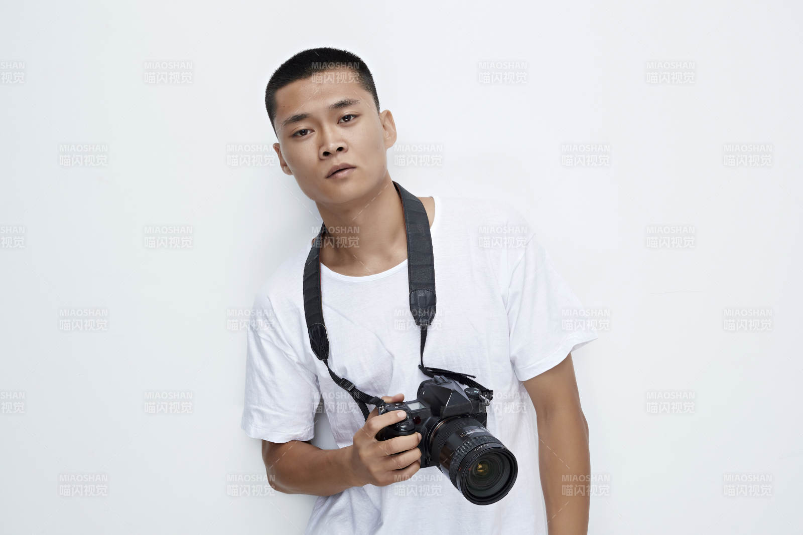 白色背景下手持照相機的亞洲男性攝影師