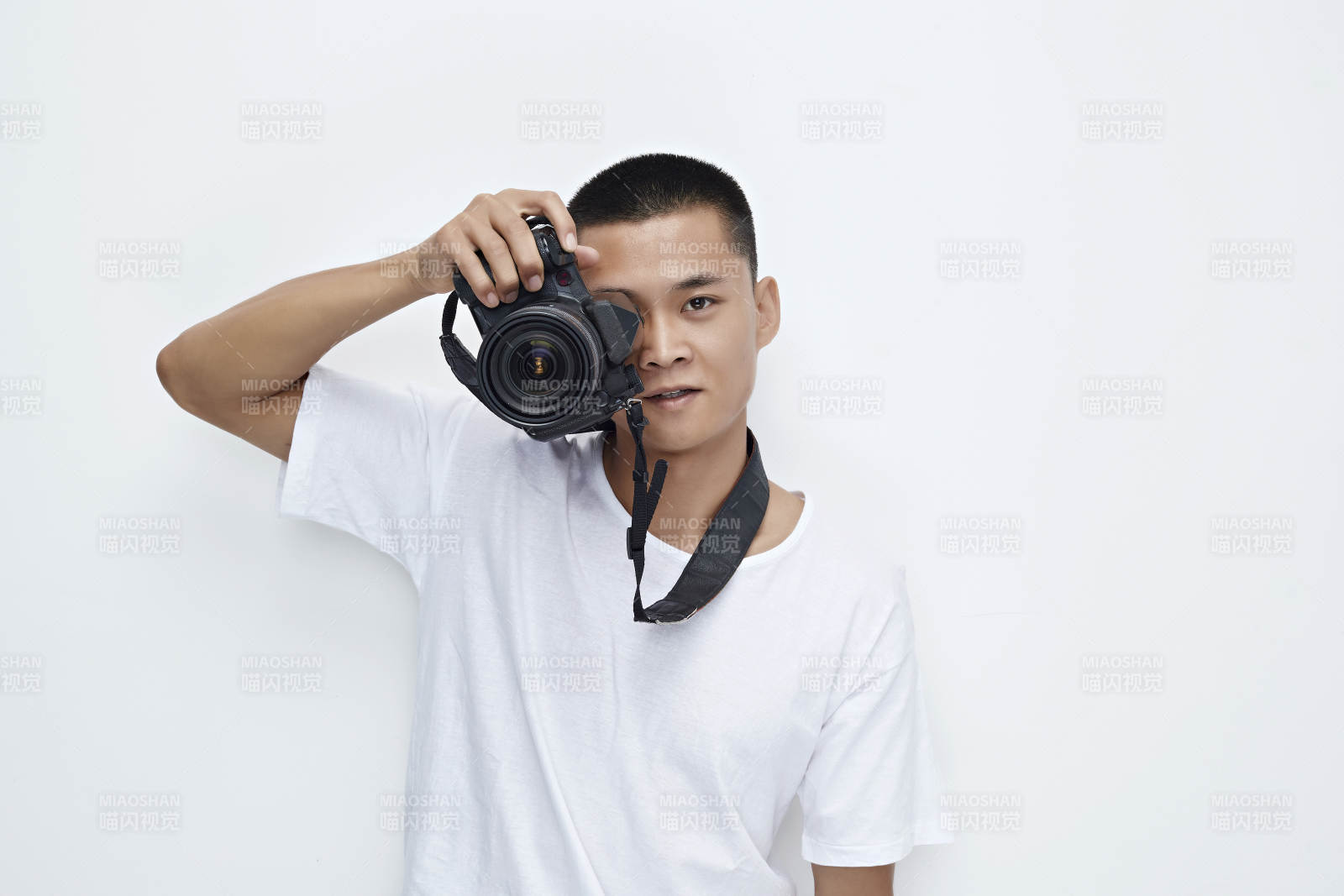 白色背景下手持照相機(jī)的亞洲男性攝影師