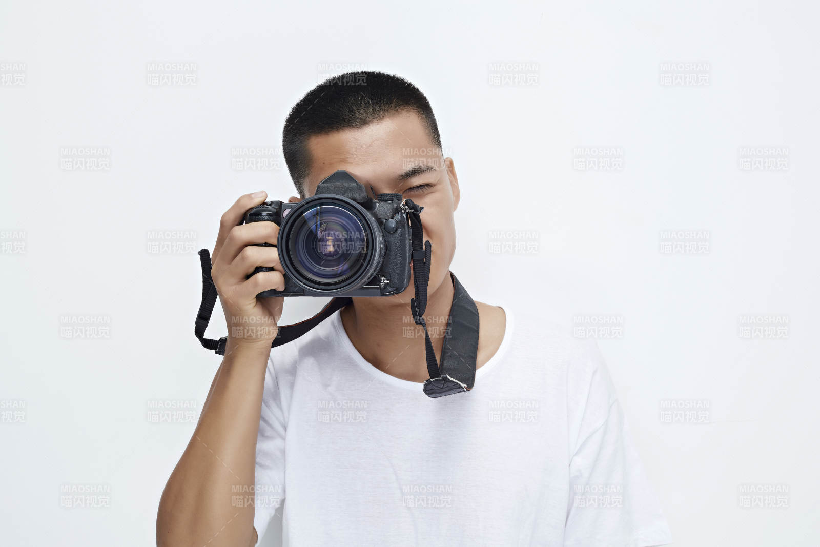 白色背景下手持照相機的亞洲男性攝影師