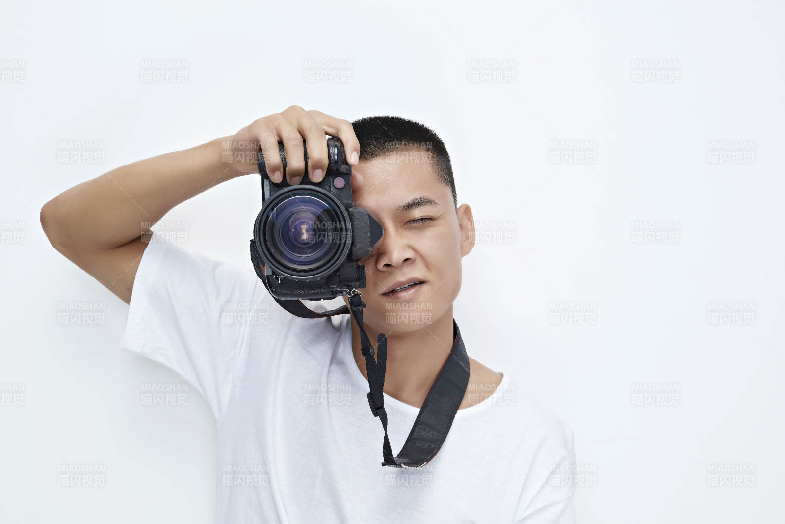 白色背景下手持照相機的亞洲男性攝影師