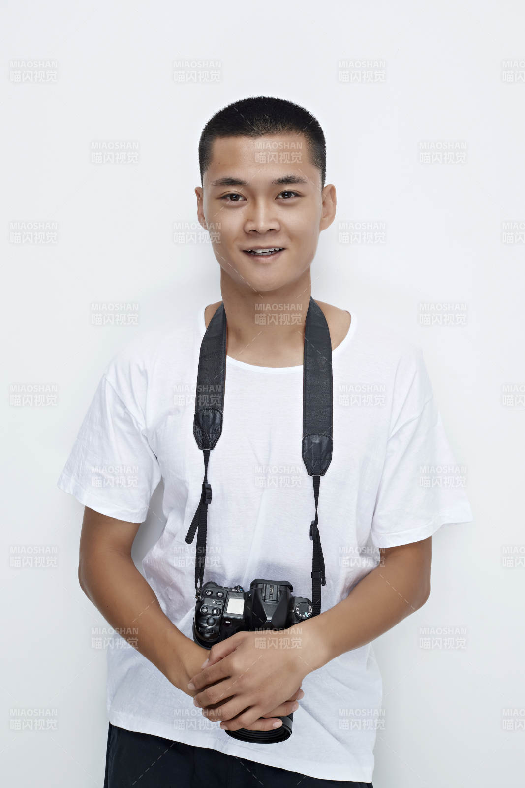 白色背景下手持照相機(jī)的亞洲男性攝影師