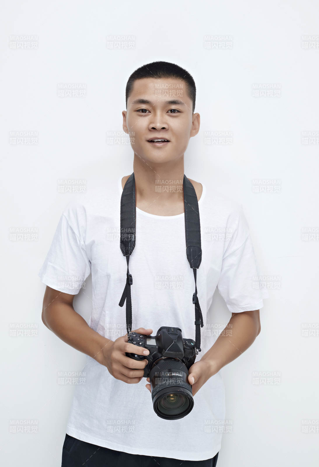 白色背景下手持照相機的亞洲男性攝影師