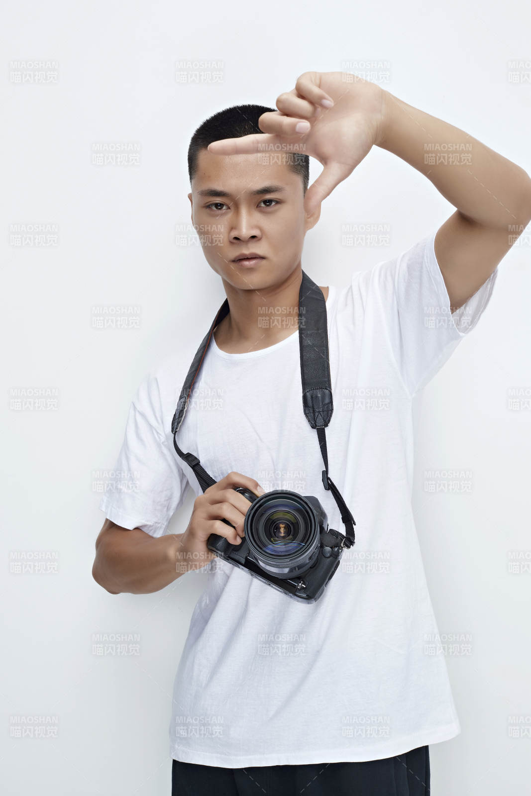 白色背景下手持照相機的亞洲男性攝影師