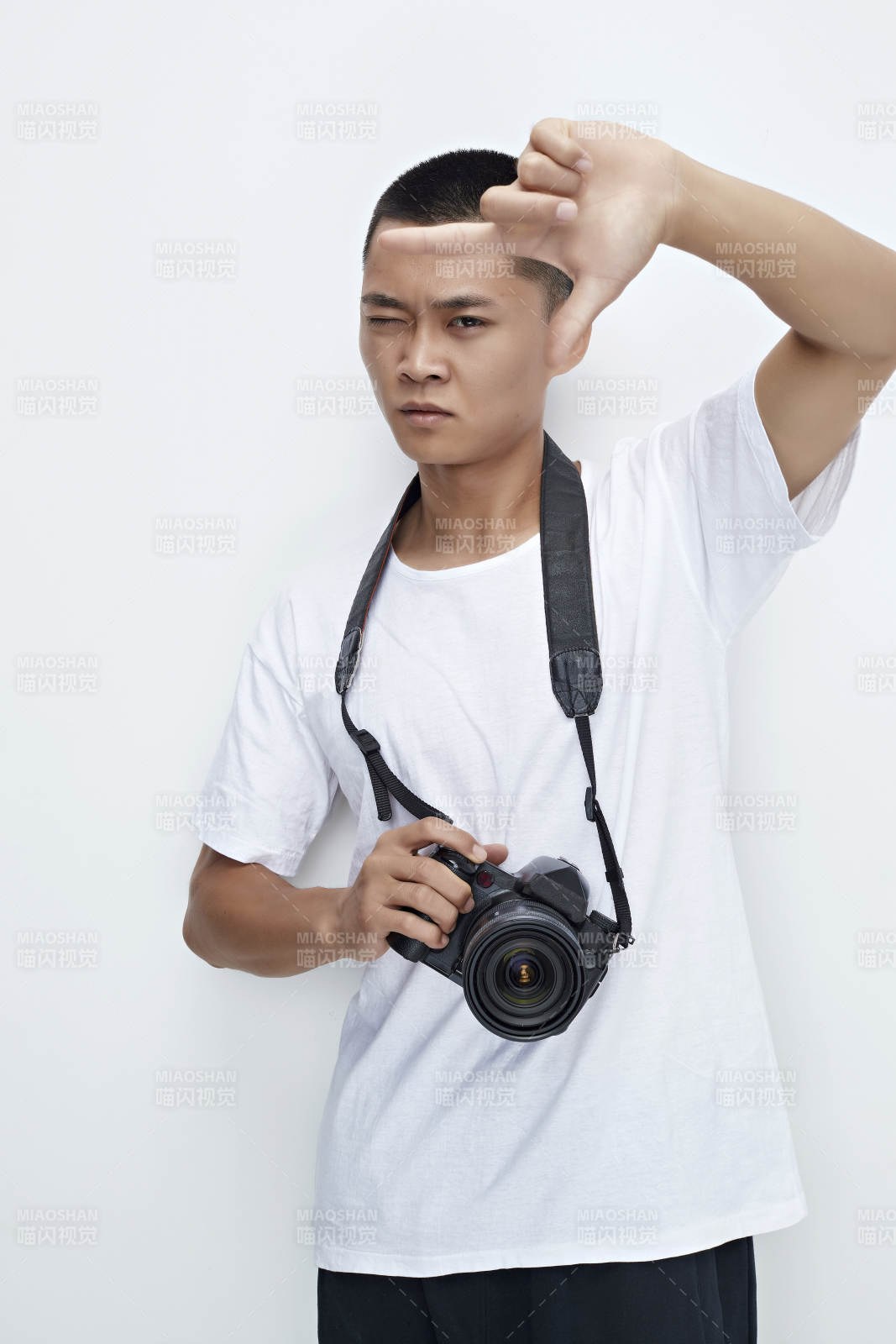 白色背景下手持照相機的亞洲男性攝影師