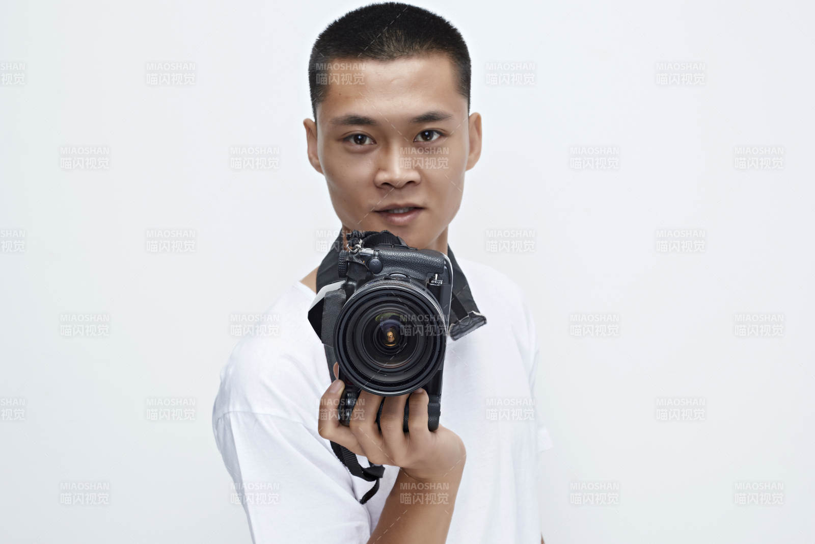 白色背景下手持照相機的亞洲男性攝影師