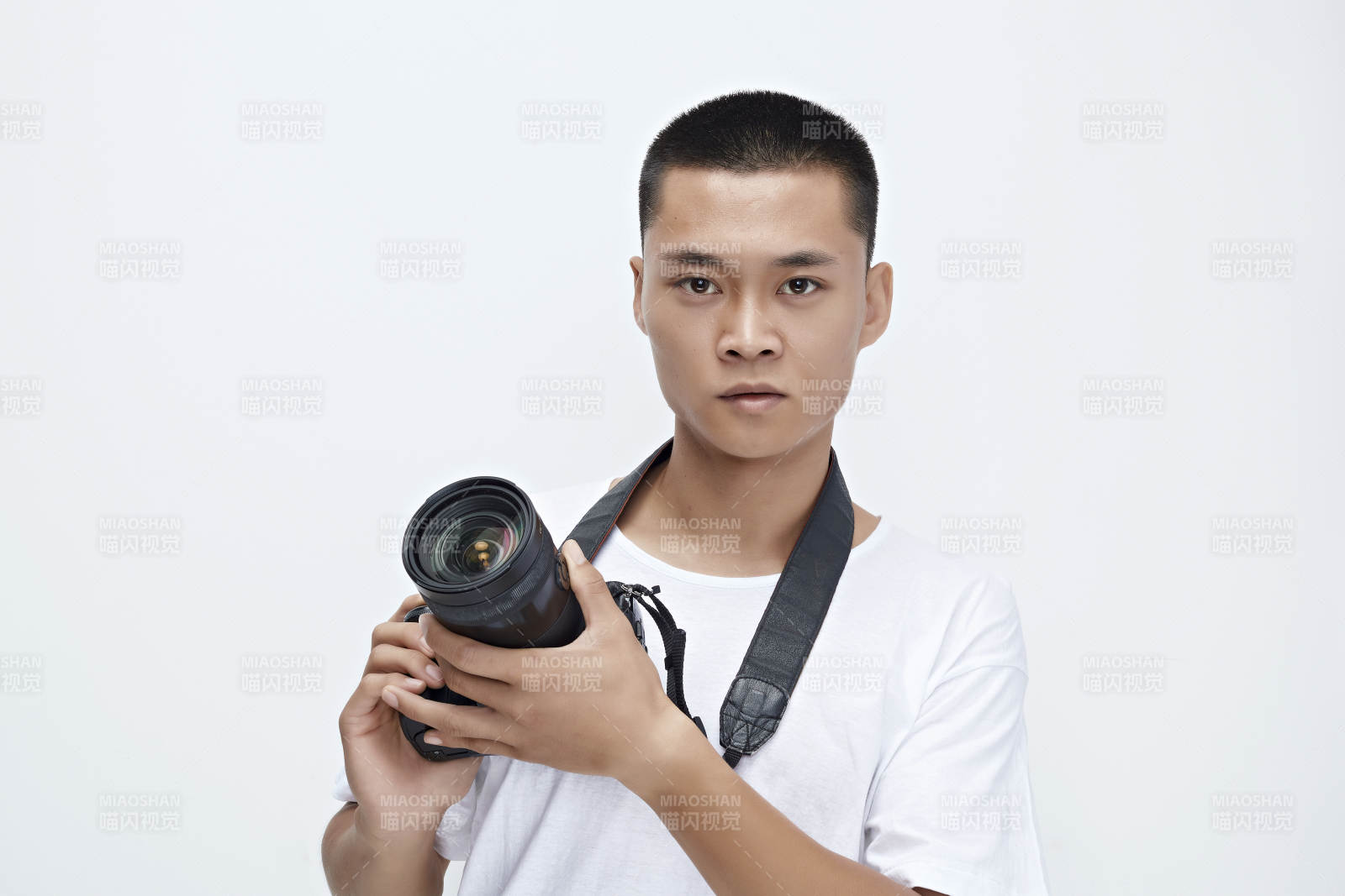 白色背景下手持照相機(jī)的亞洲男性攝影師