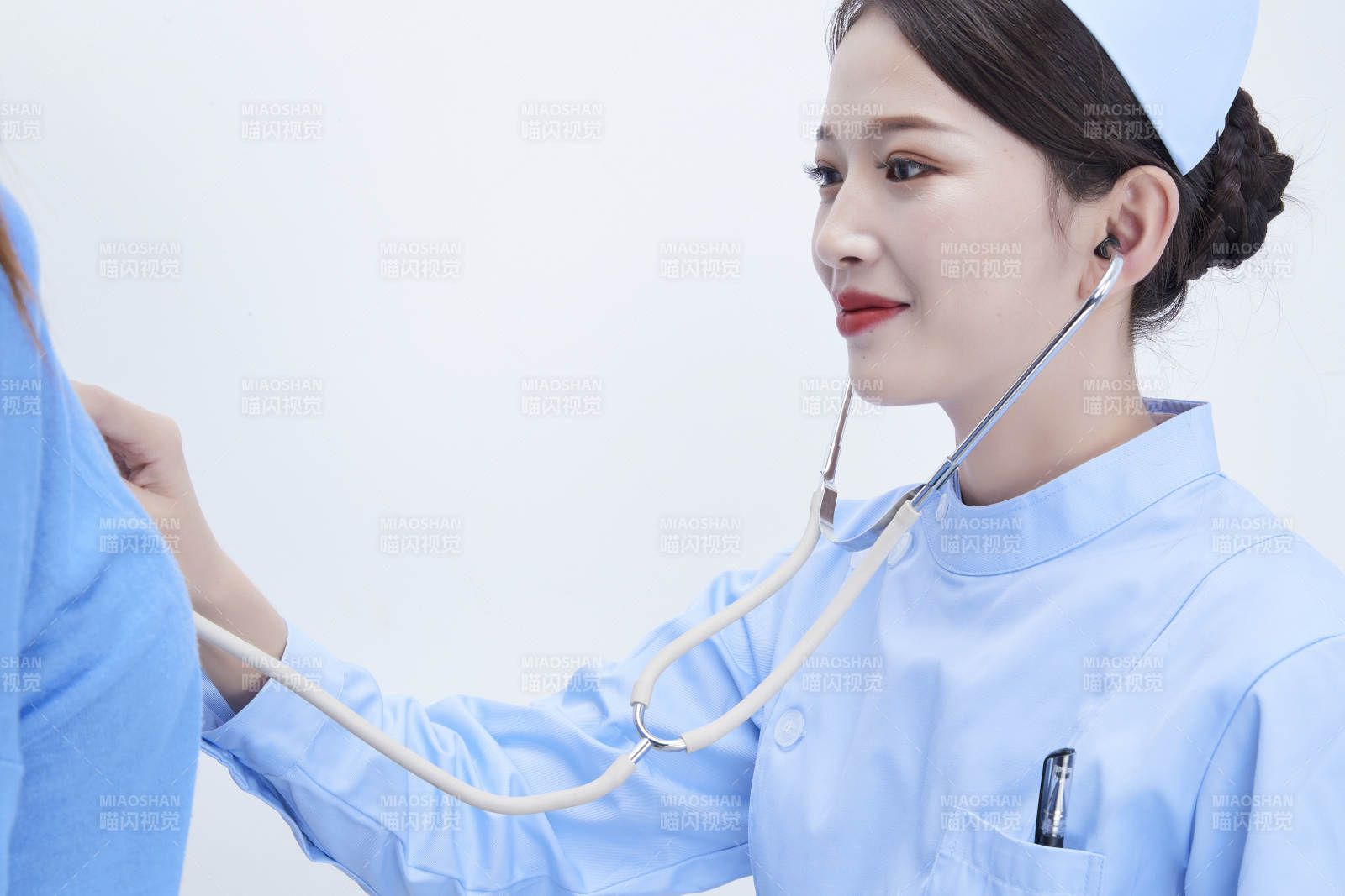 佩戴聽診器的女性醫(yī)護人員為患者聽診檢查