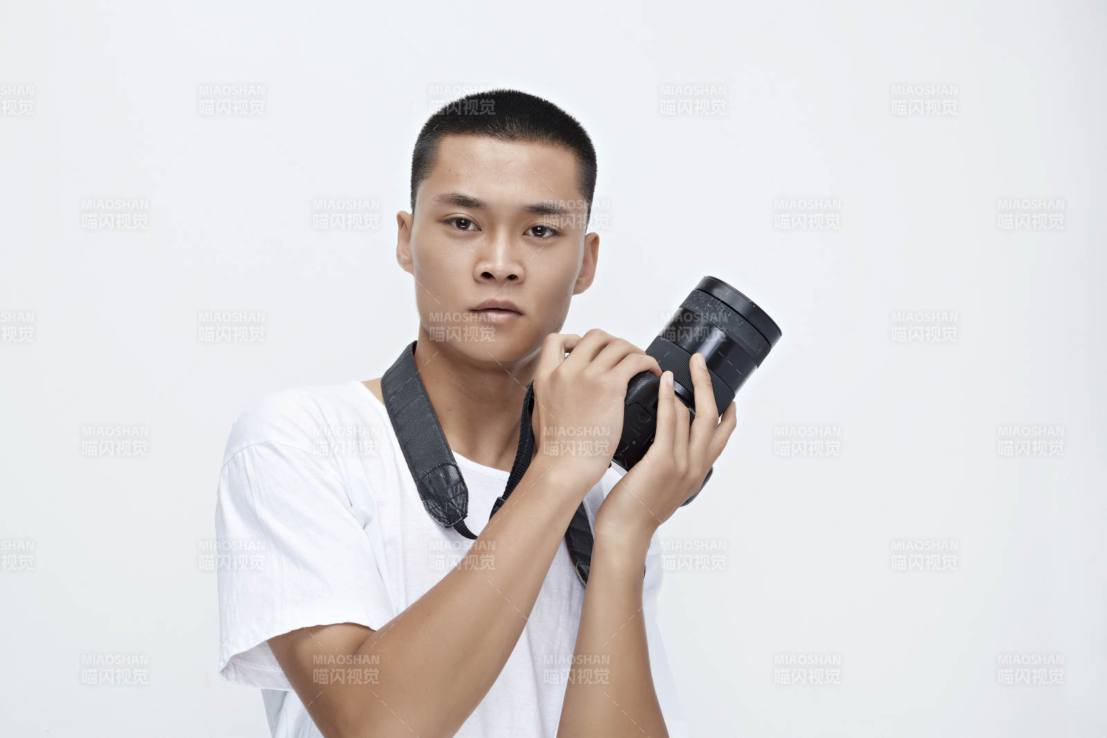 白色背景下手持照相機的亞洲男性攝影師