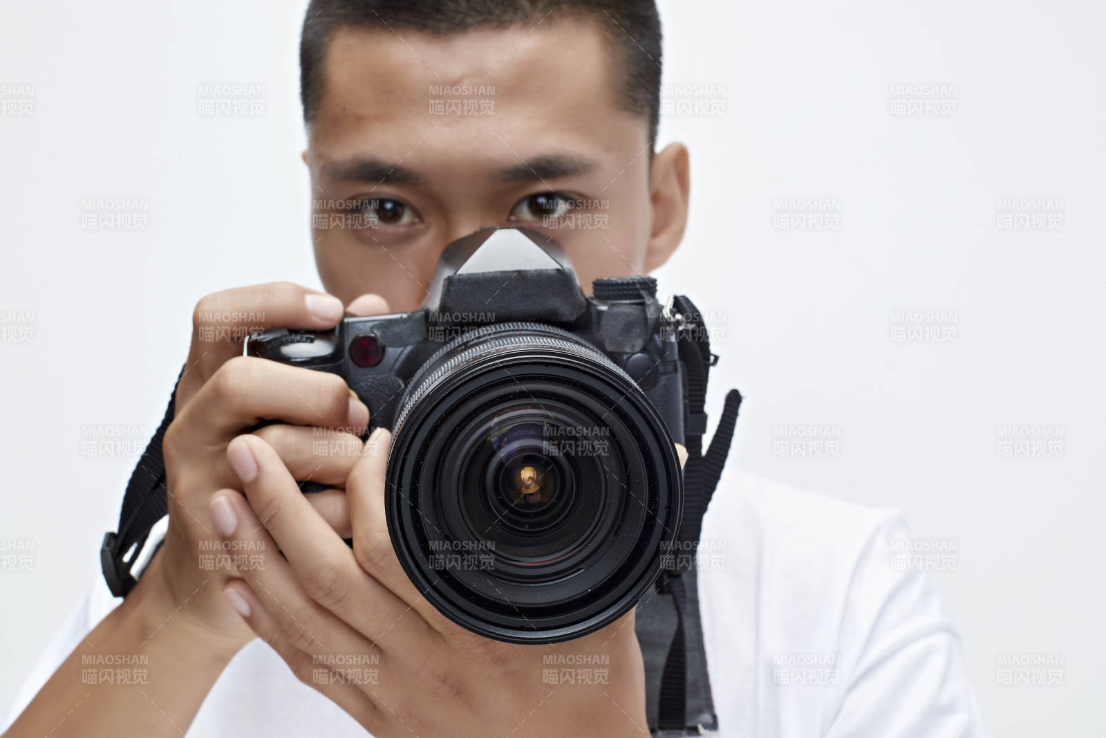 白色背景下手持照相機的亞洲男性攝影師
