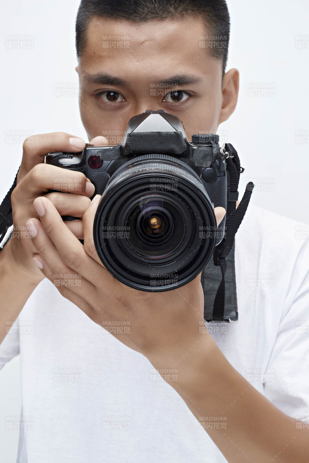 白色背景下手持照相機的亞洲男性攝影師
