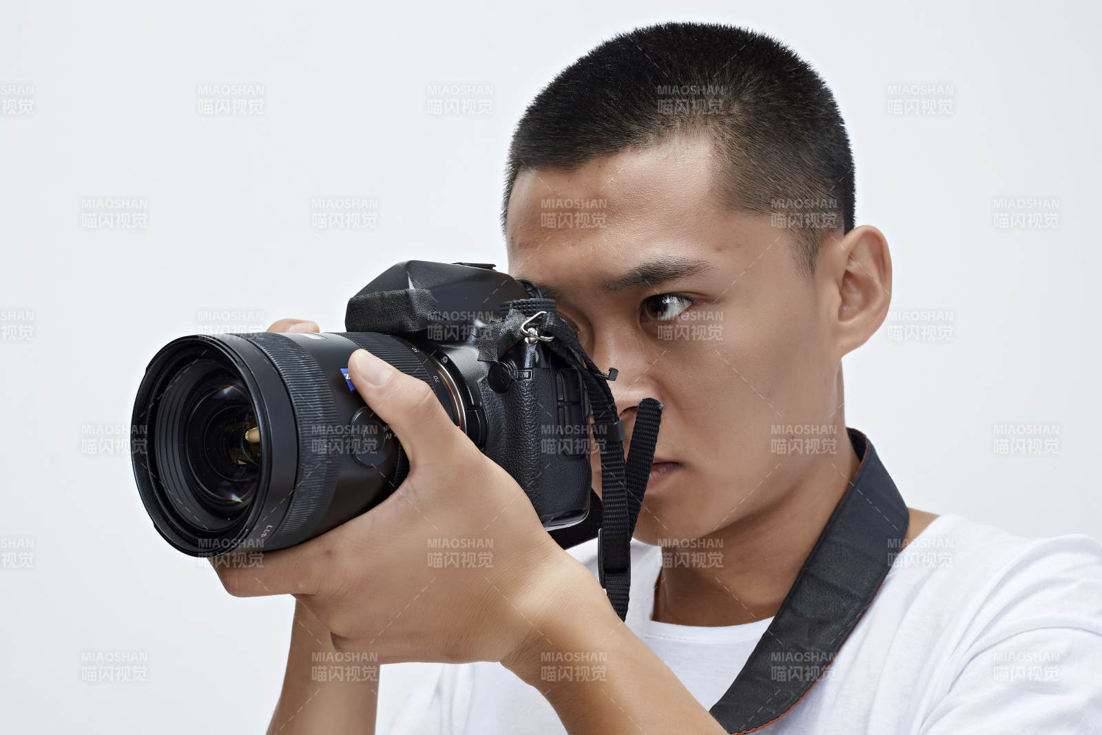 白色背景下手持照相機的亞洲男性攝影師