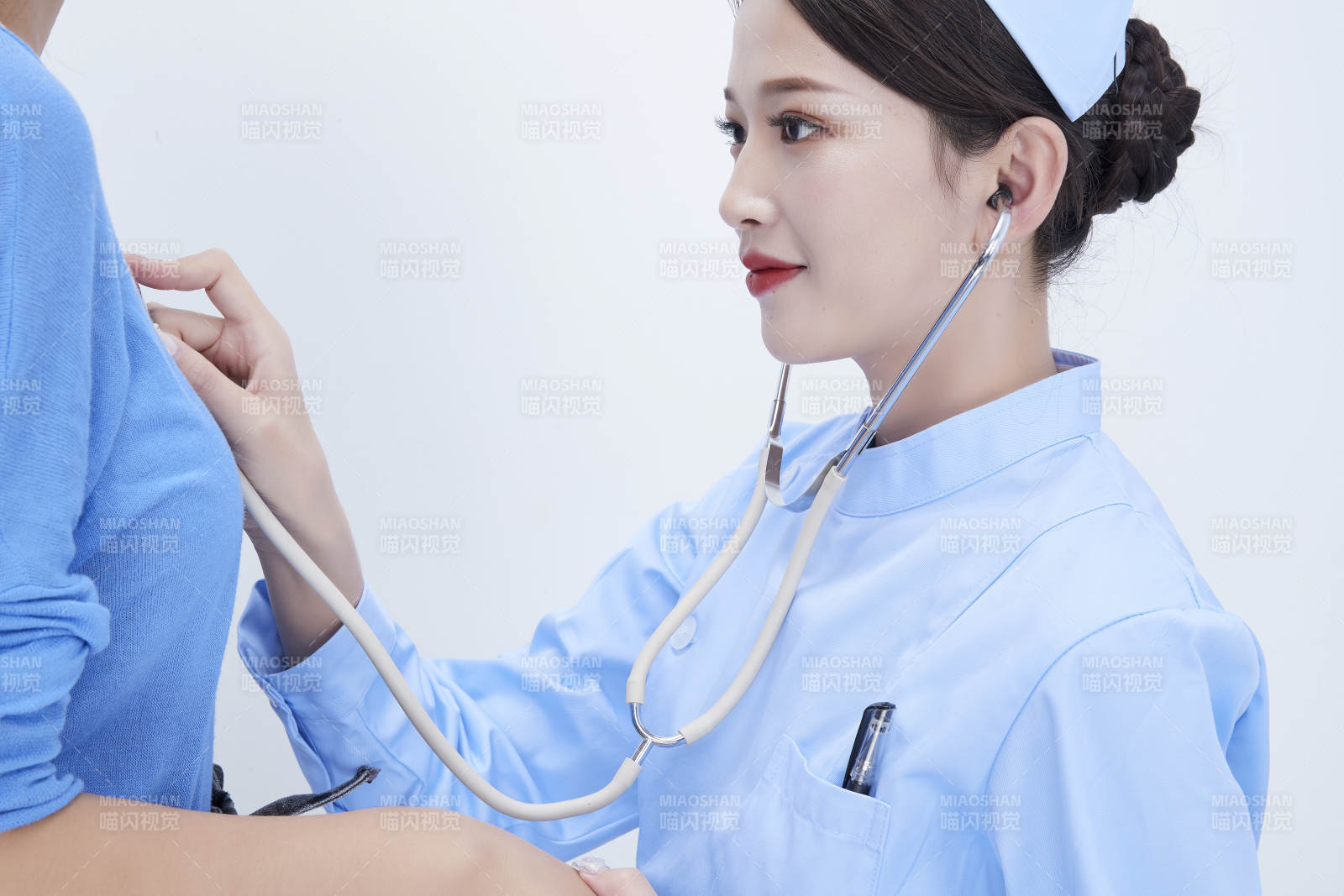 佩戴聽診器的女性醫(yī)護(hù)人員為患者聽診檢查