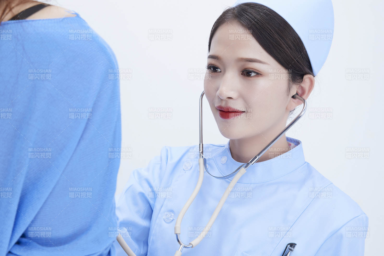 佩戴聽診器的女性醫護人員為患者聽診檢查