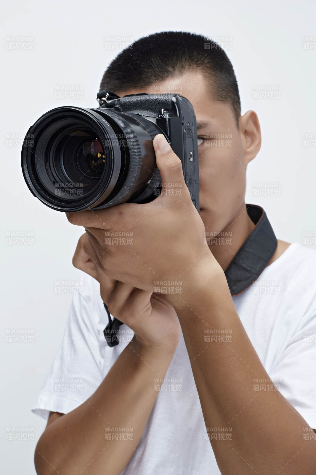 白色背景下手持照相機的亞洲男性攝影師