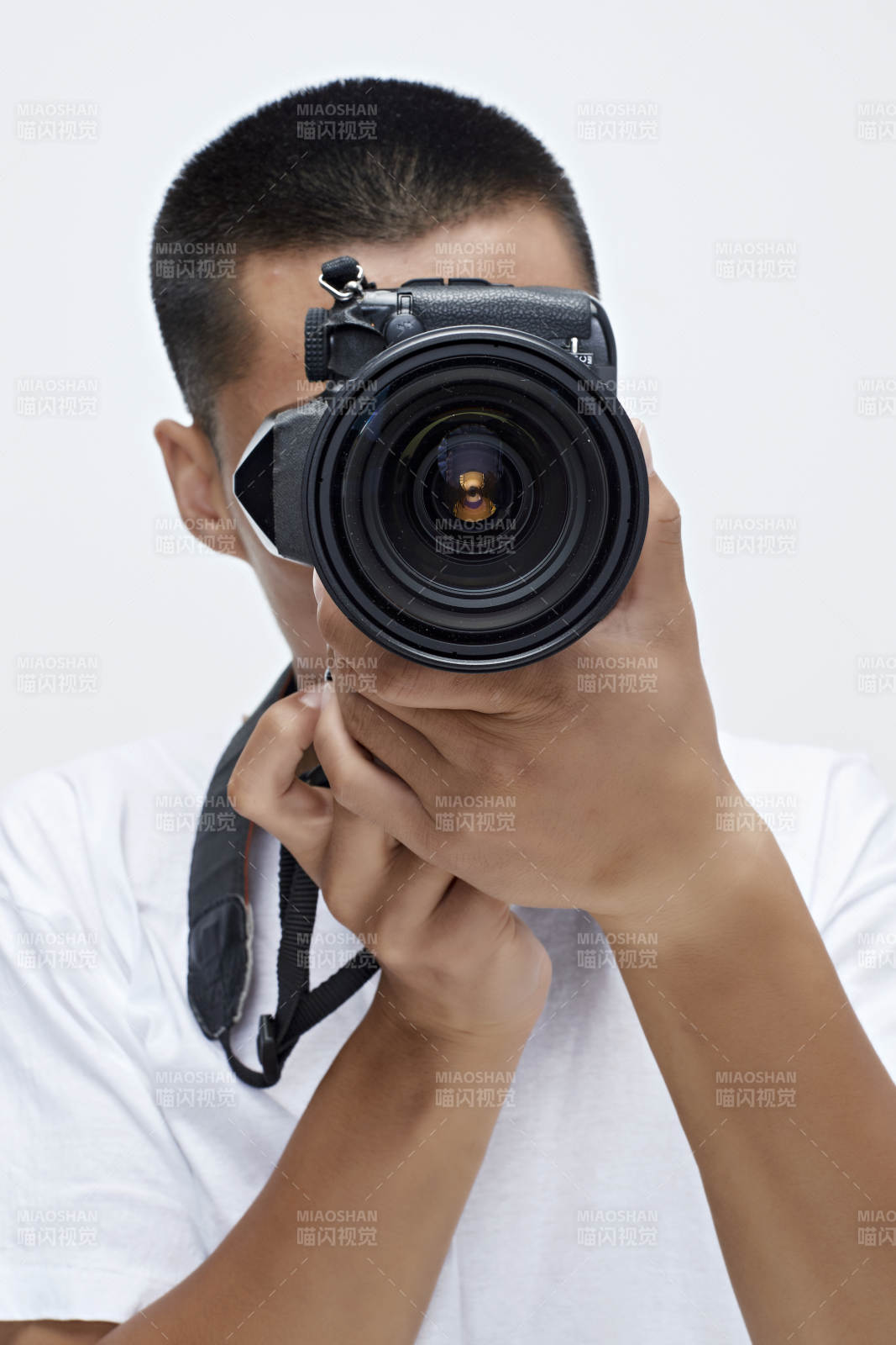 白色背景下手持照相機(jī)的亞洲男性攝影師