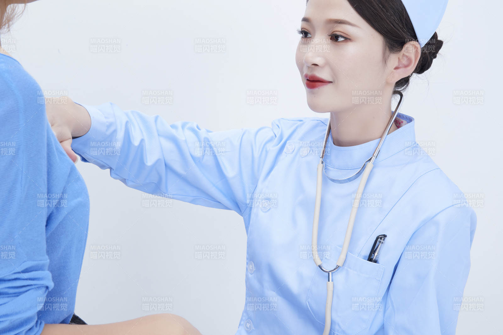 年輕的女性醫護人員為患者進行身體按壓檢查