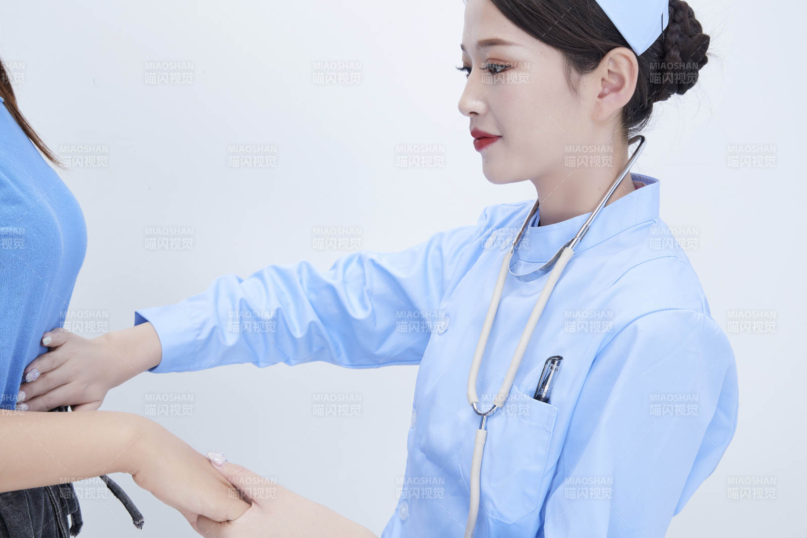 年輕的女性醫護人員為患者進行身體按壓檢查