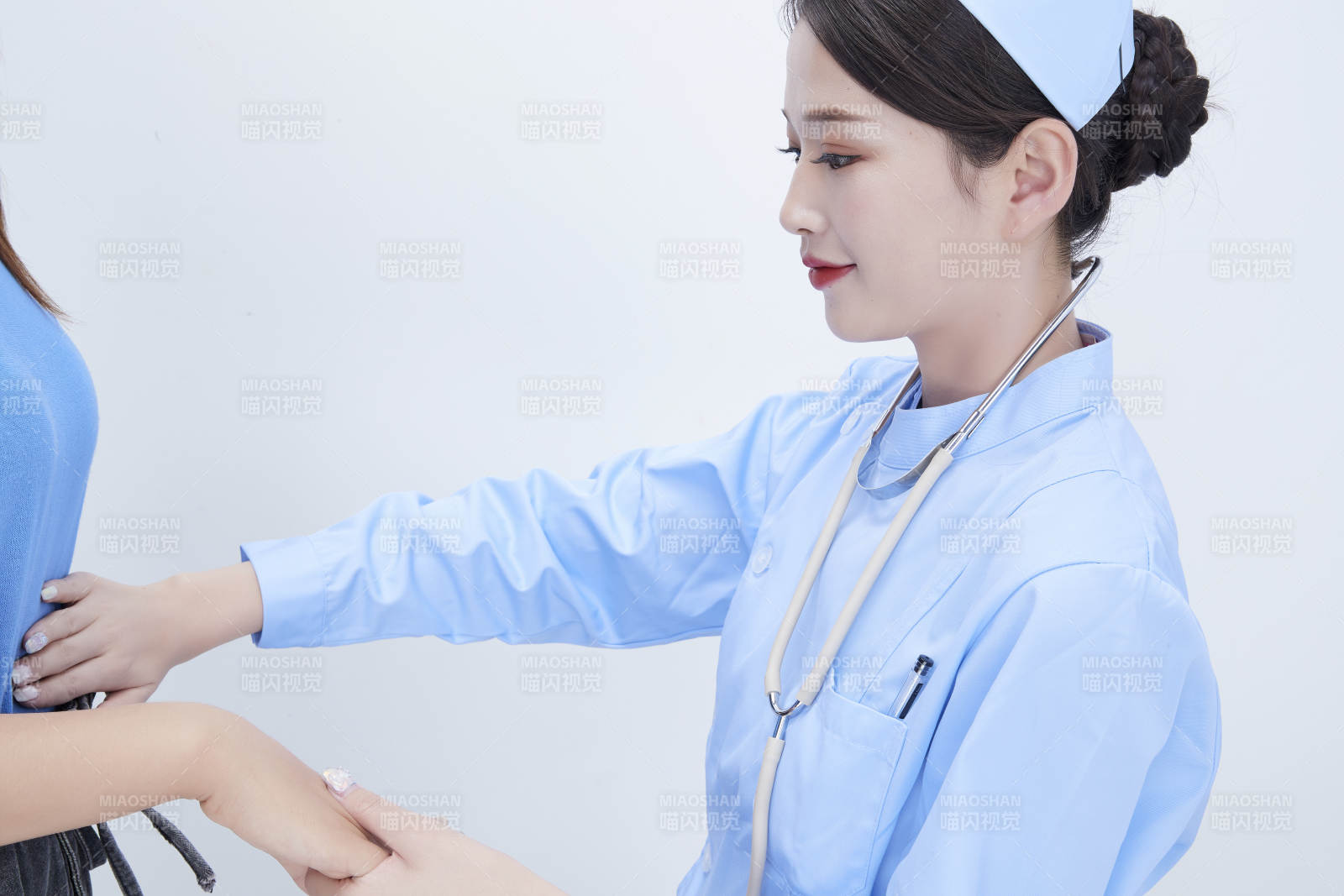 年輕的女性醫護人員為患者進行身體按壓檢查