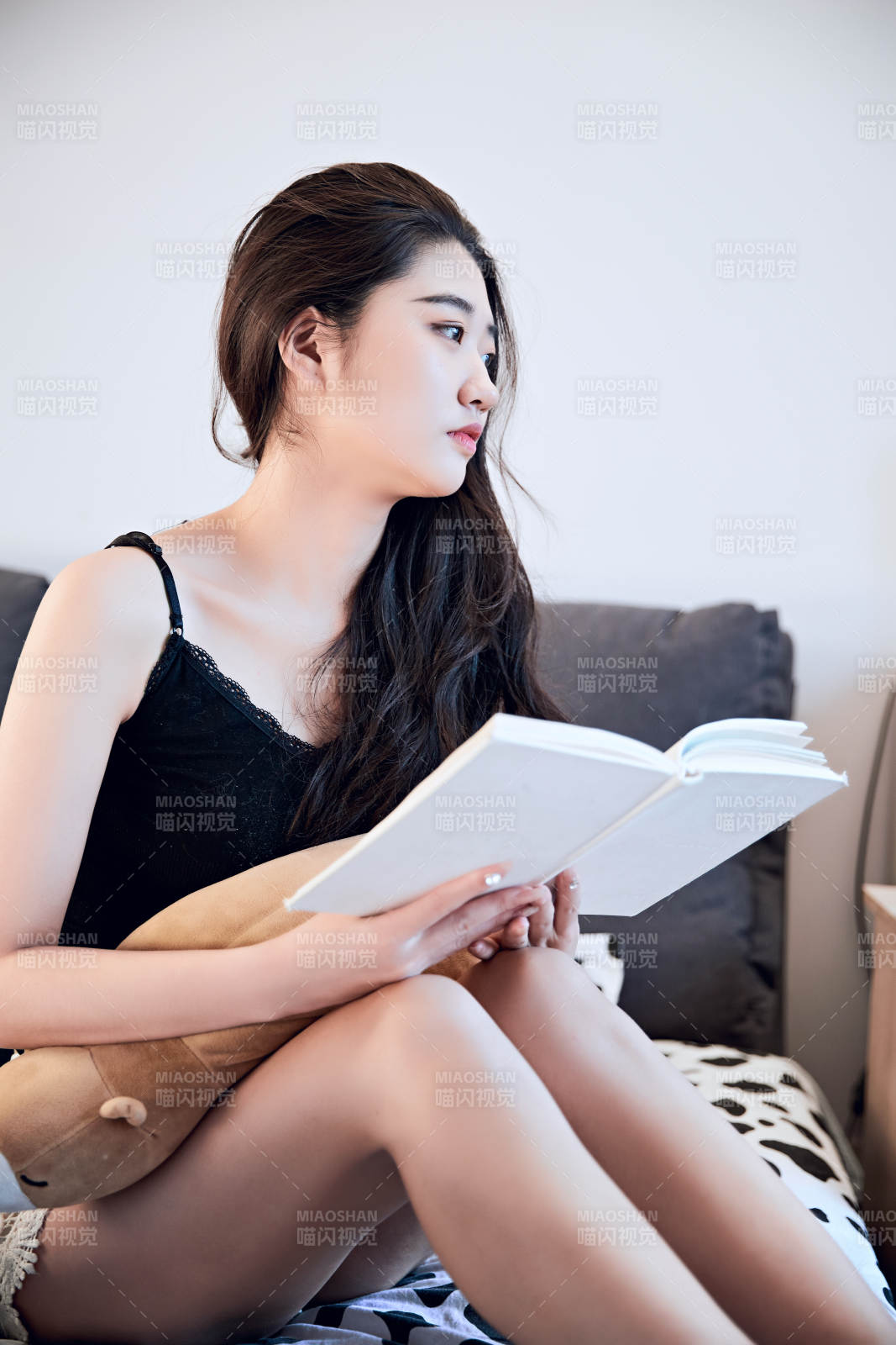 在床上閱讀書籍的年輕女孩