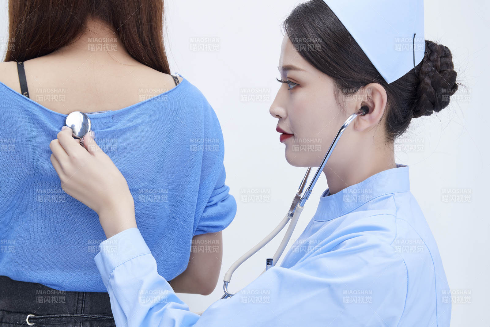 佩戴聽診器的女性醫護人員為患者聽診檢查