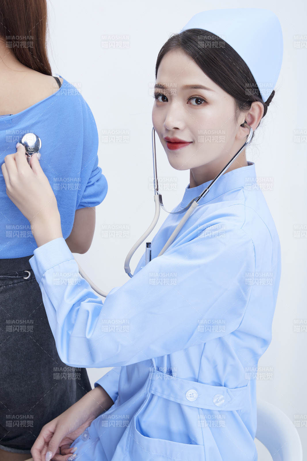 佩戴聽診器的女性醫(yī)護(hù)人員為患者聽診檢查