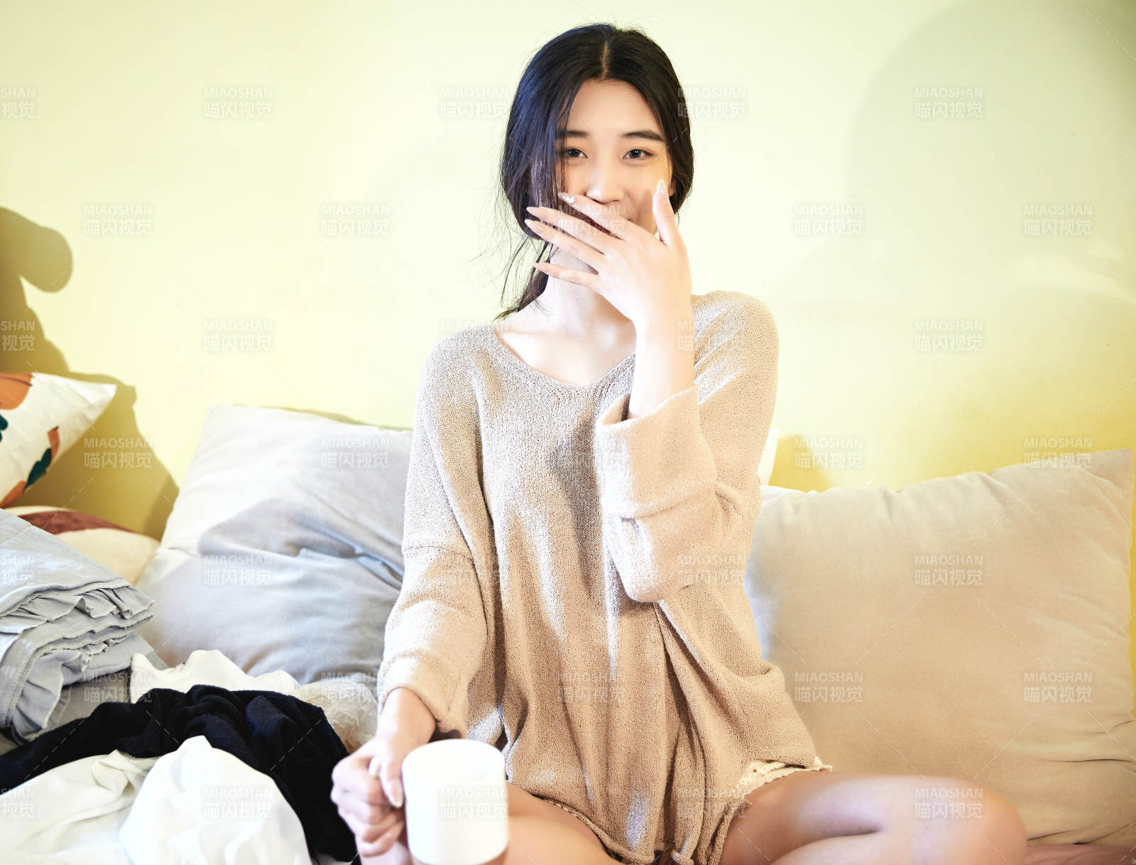 在沙發床上整理行裝的年輕亞洲女性